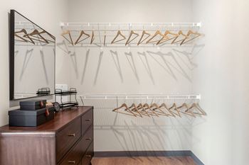 a walk in closet with a dresser and mirror